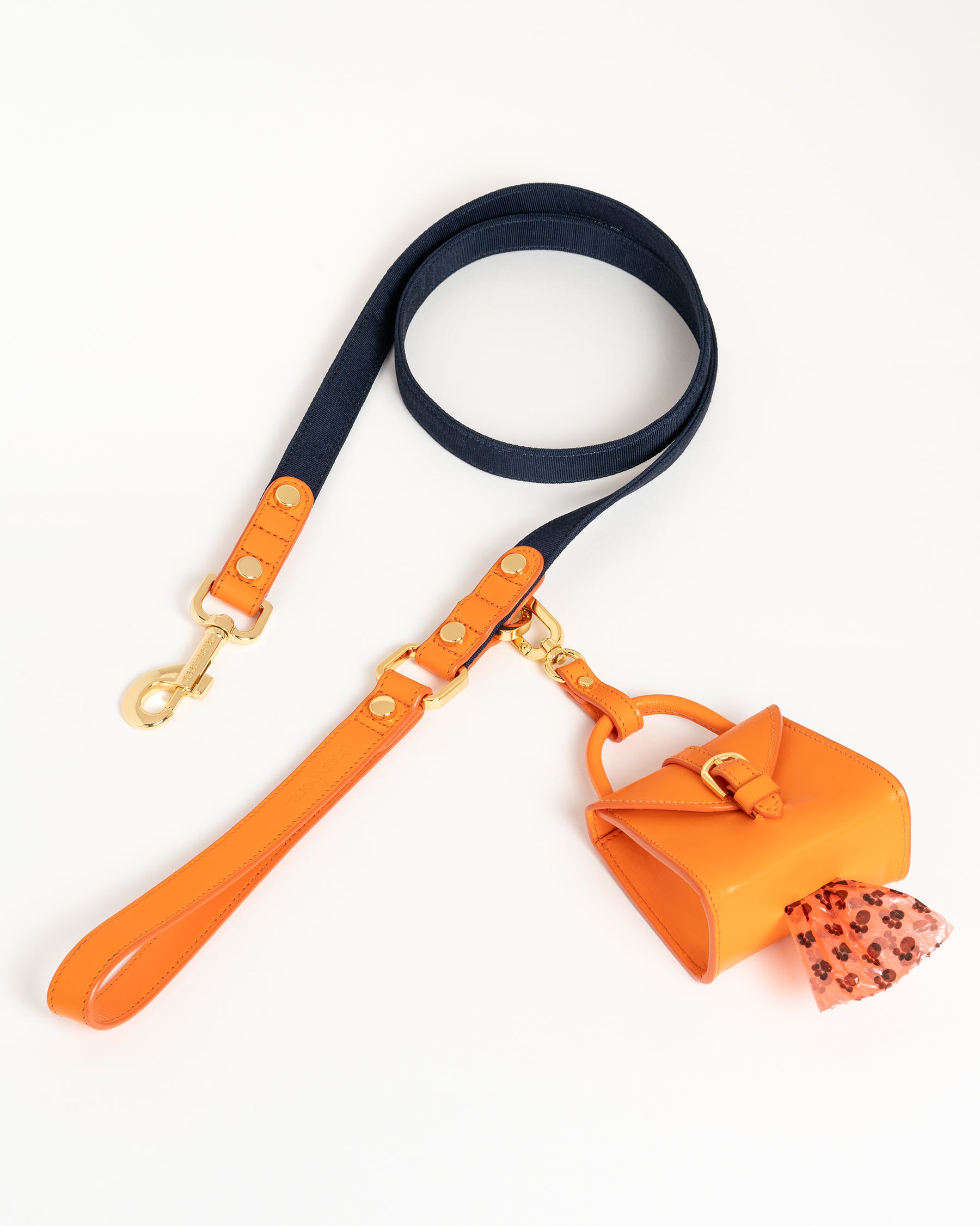 Dear Nora Tangerine dog leash and poop bag holder - orange leather, navy blue fabric and 24k plated hardware - top down shot