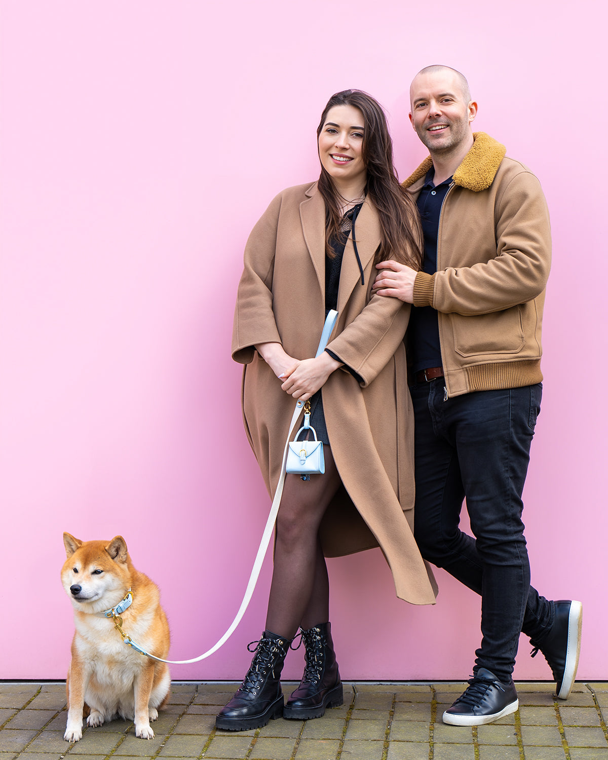 Les fondateurs de Dear Nora souriants et se tenant debout devant un fond rose
